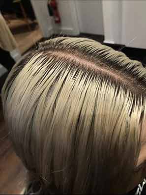 Close up of a woman's blonde roots hair