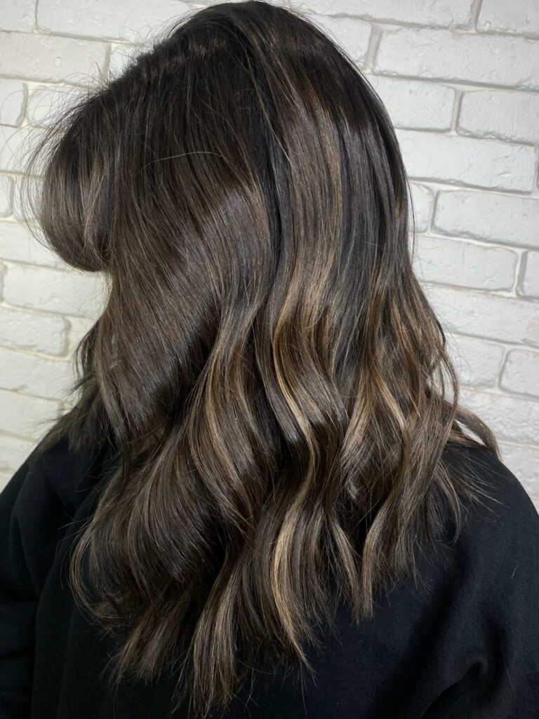 Dark brunette hair with subtle sun-kissed highlights from a Reverse-Balayage